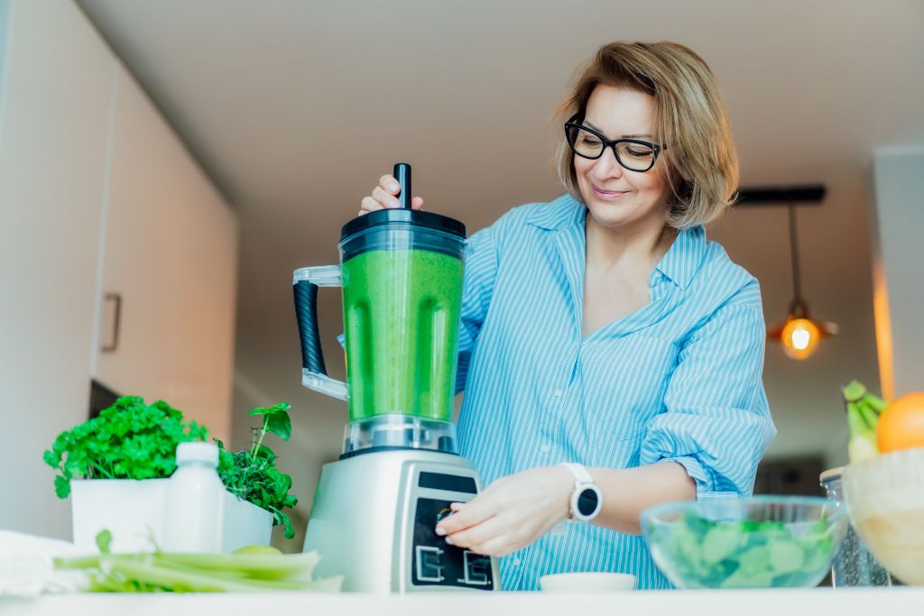 Nainen tekee smoothieta.