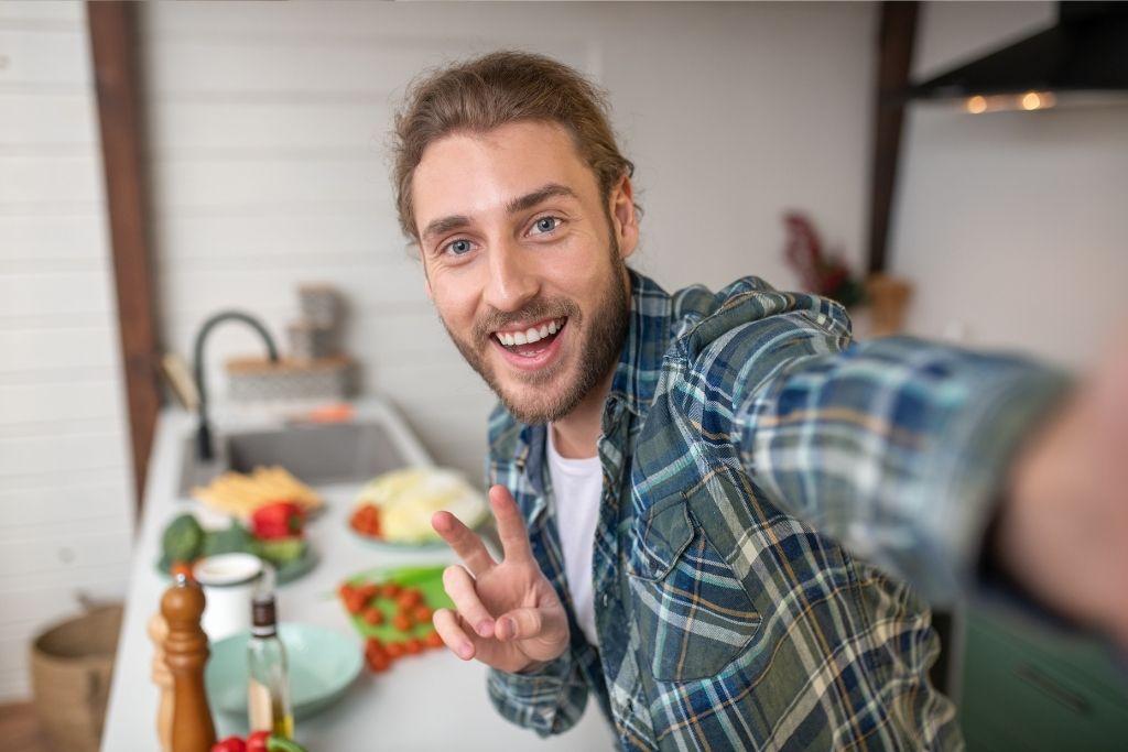 Nuori vegaanimies hymyilee selfiessä