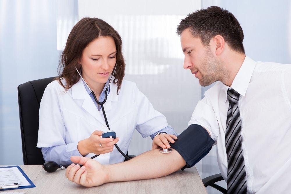 Lääkäri mittaa nuoren aikuisen verenpainetta